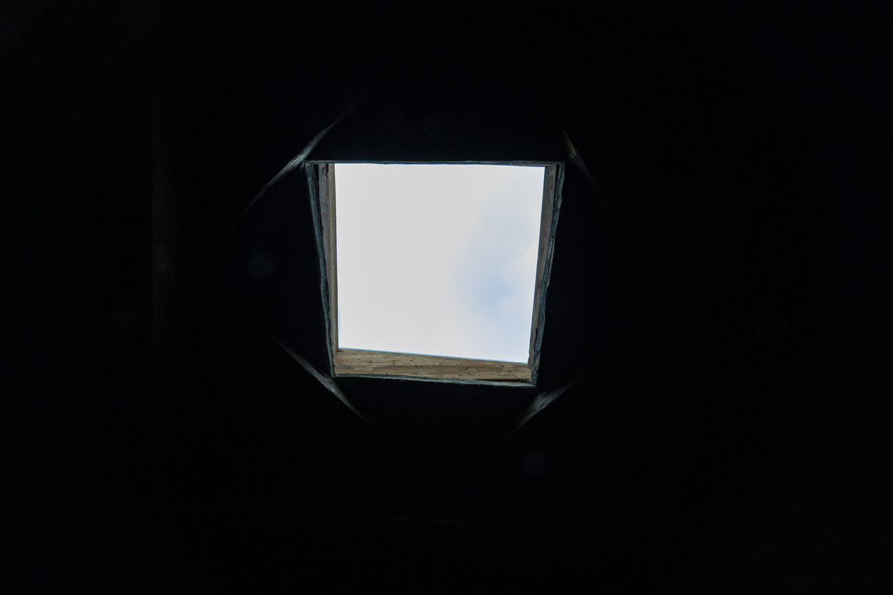 Window of hope. The dark background ceiling with a sunroof window, proving sunlight and creating the concept of hope in the darkness.
